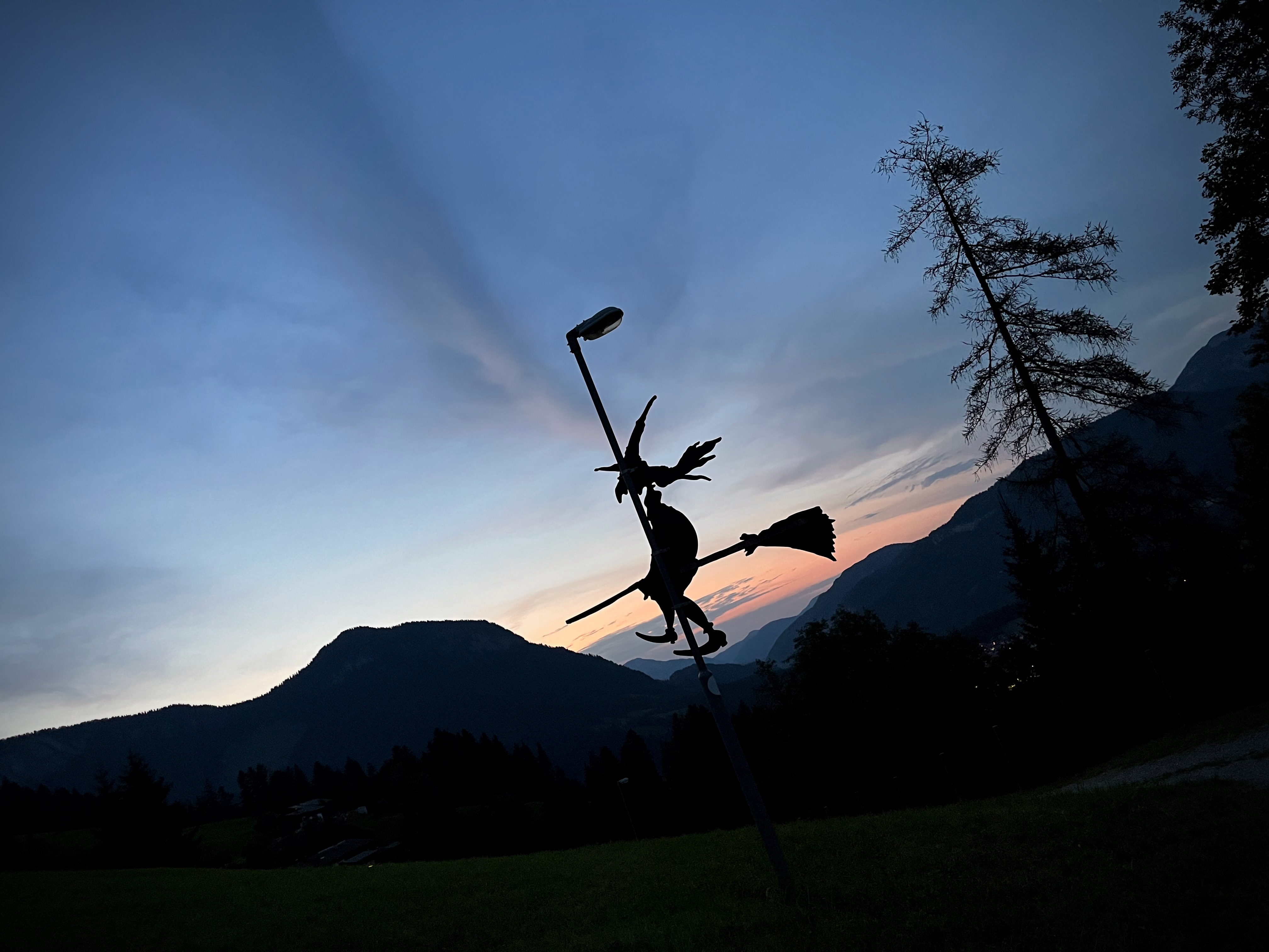 A witch on a broomstick silhouetted against the night sky. 